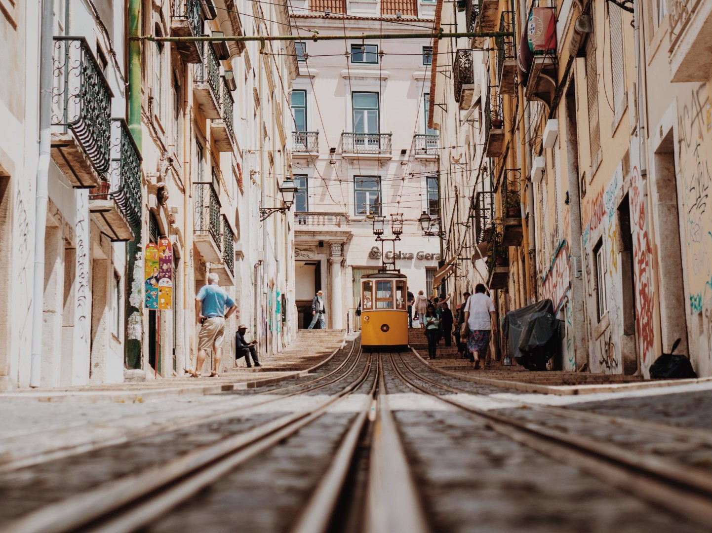 The article's cover image: 7 Reasons to Visit Portugal in 2023. In the image, people are passing by the Bica lift in Lisbon.